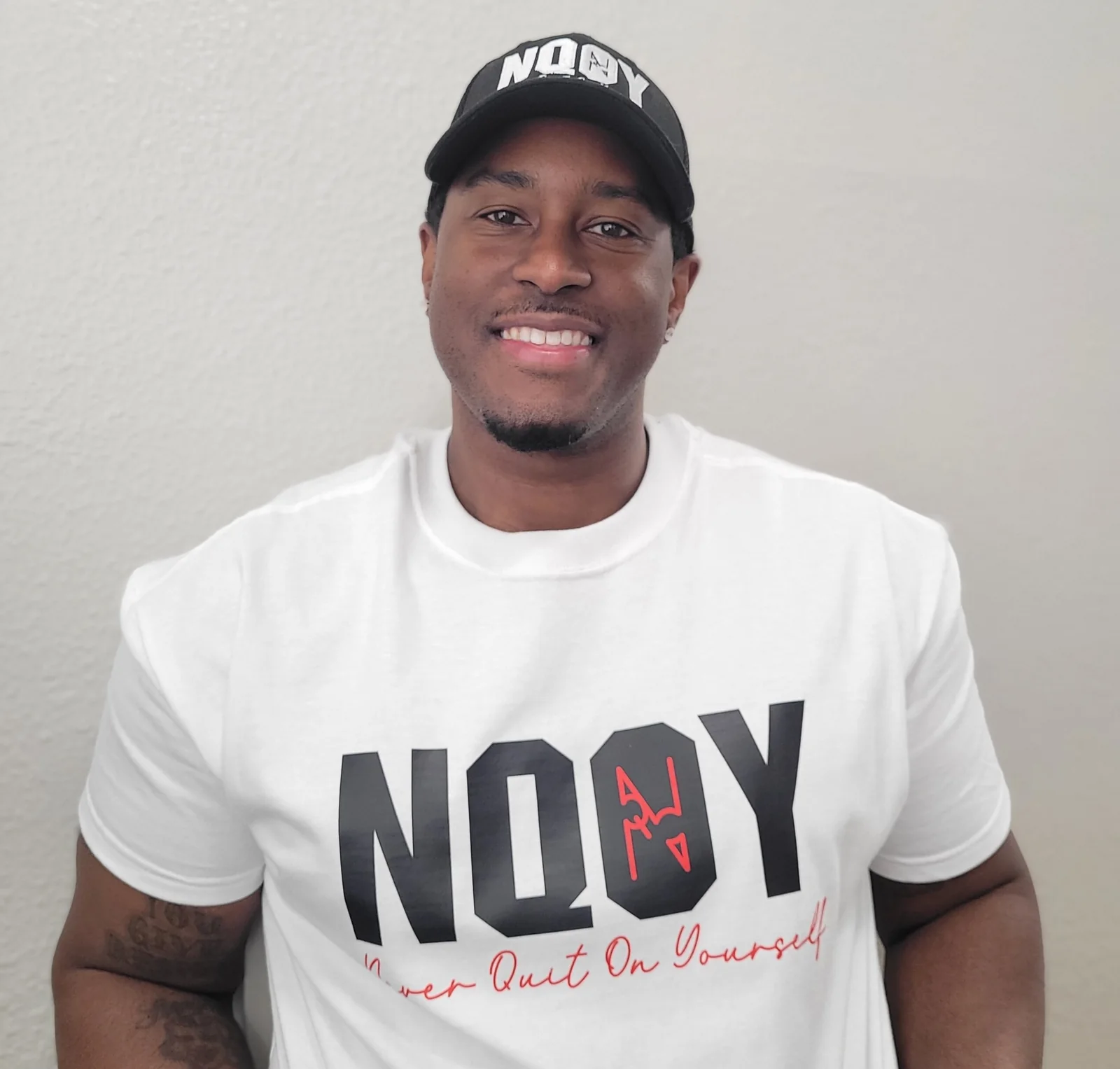 Kevin Coates wearing an NQOY tee and cap